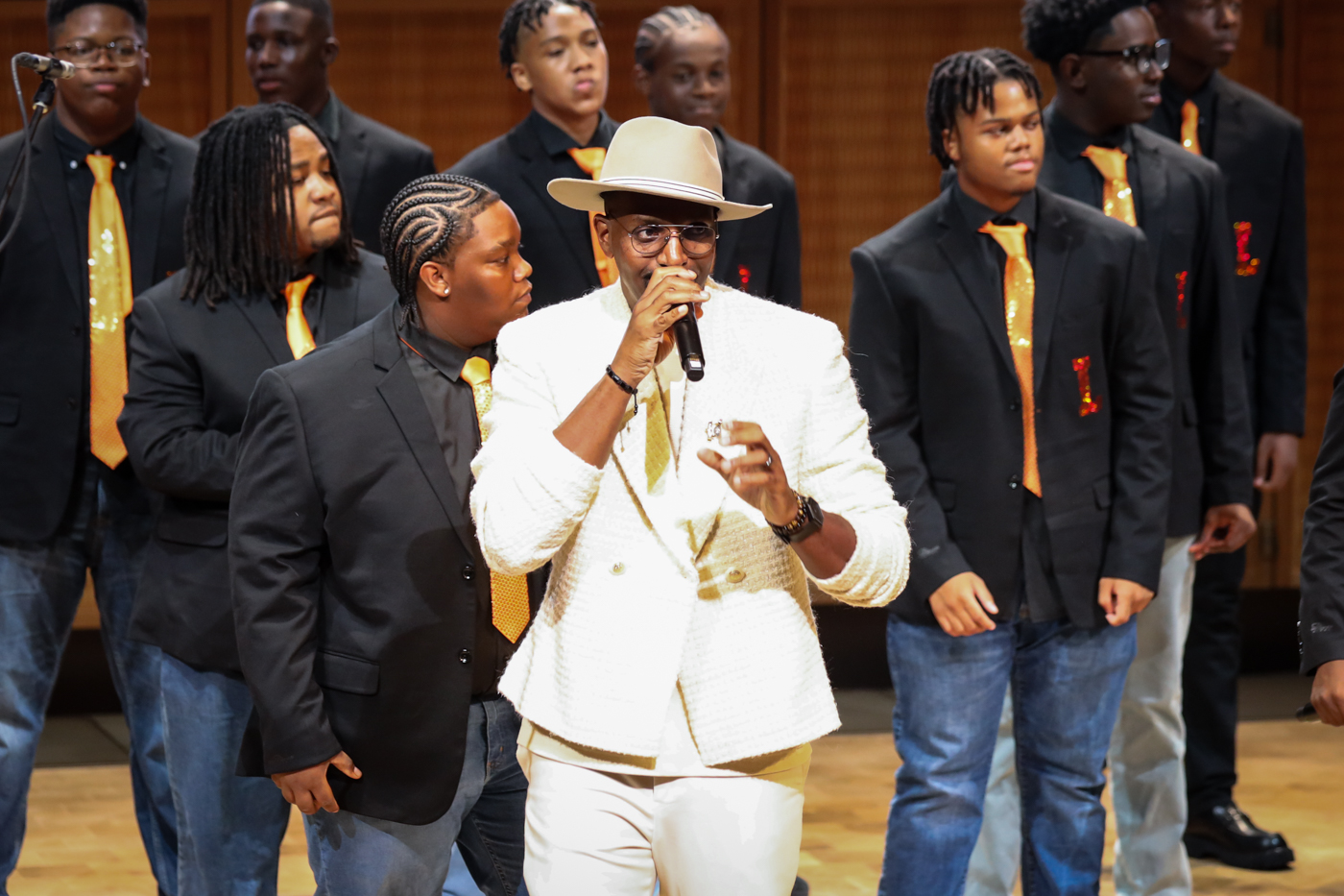 The Leo Choir performing on stage with a guest vocalist in a white suit