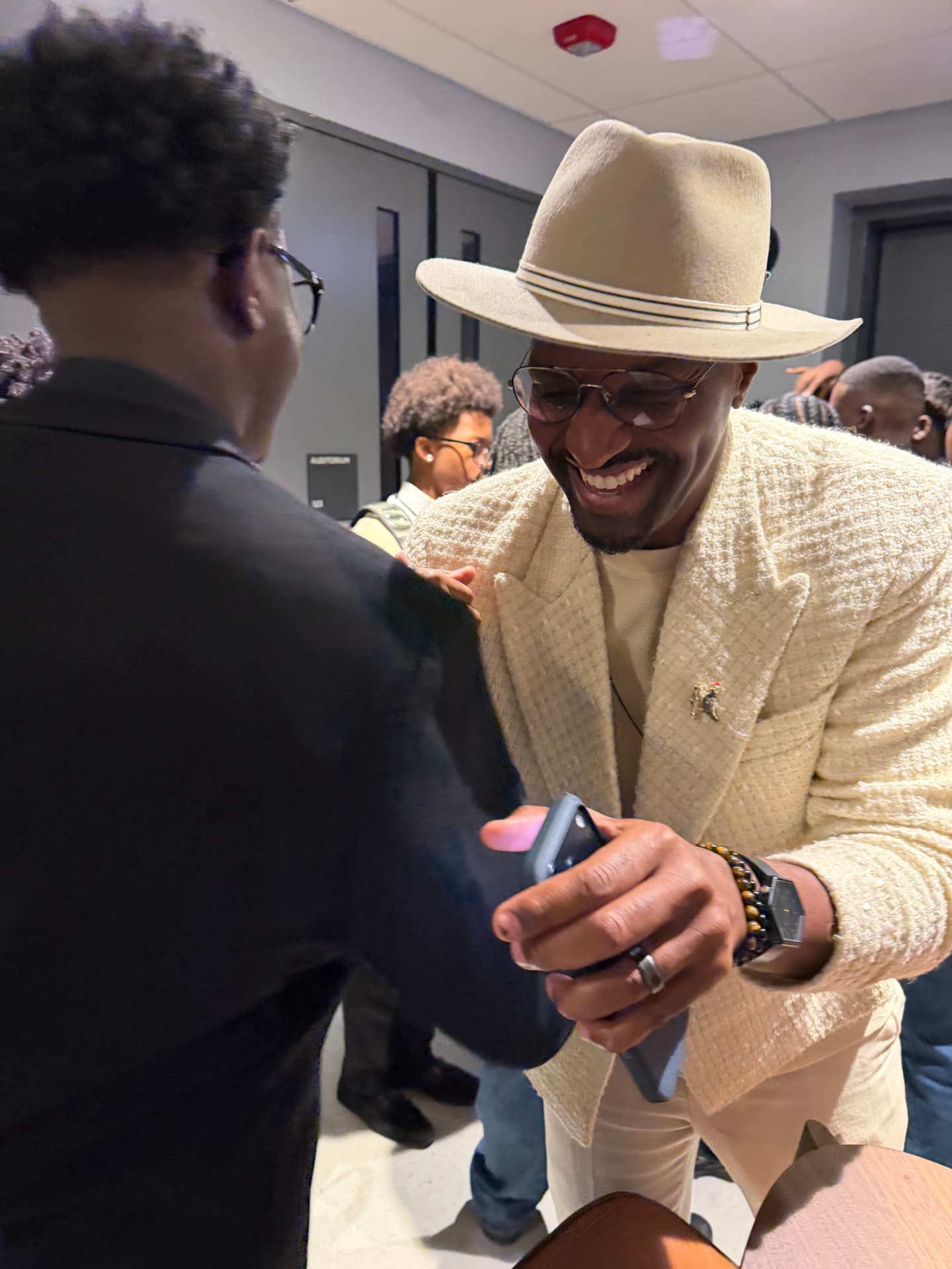 The guest artist laughing as he greets a student backstage