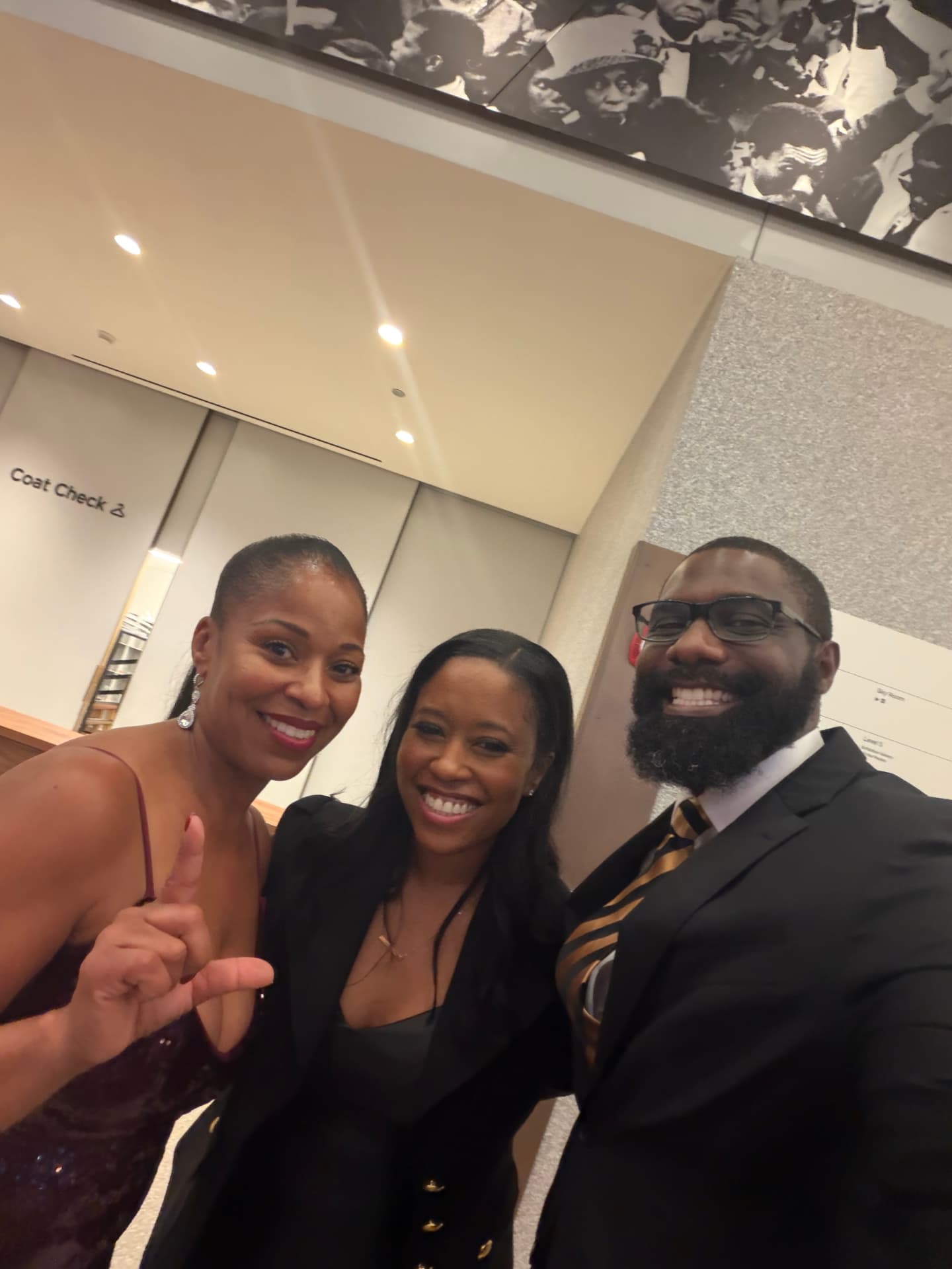 Three guests smiling together in a selfie in the lobby