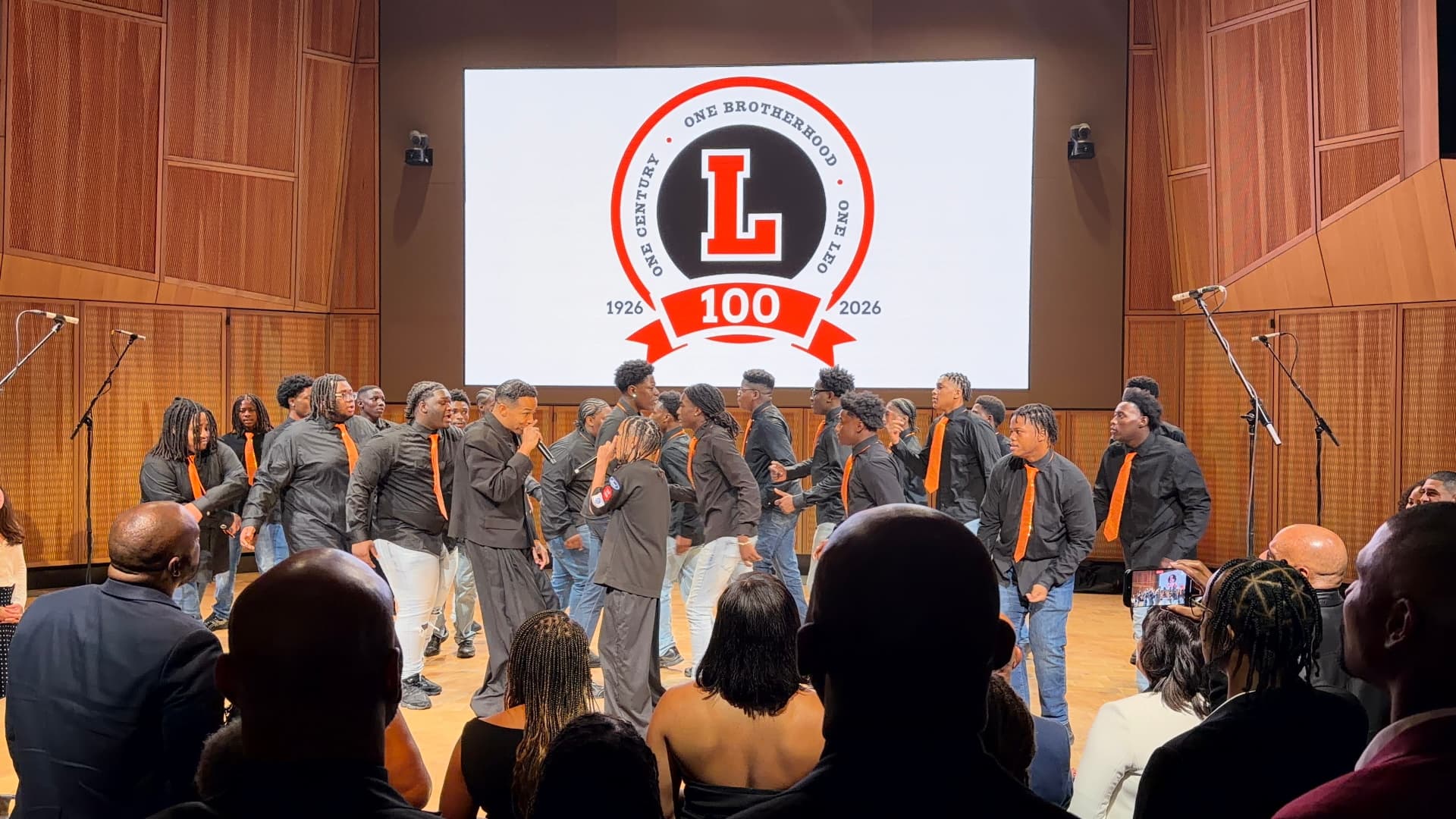 The choir circling two guest vocalists during a lively number