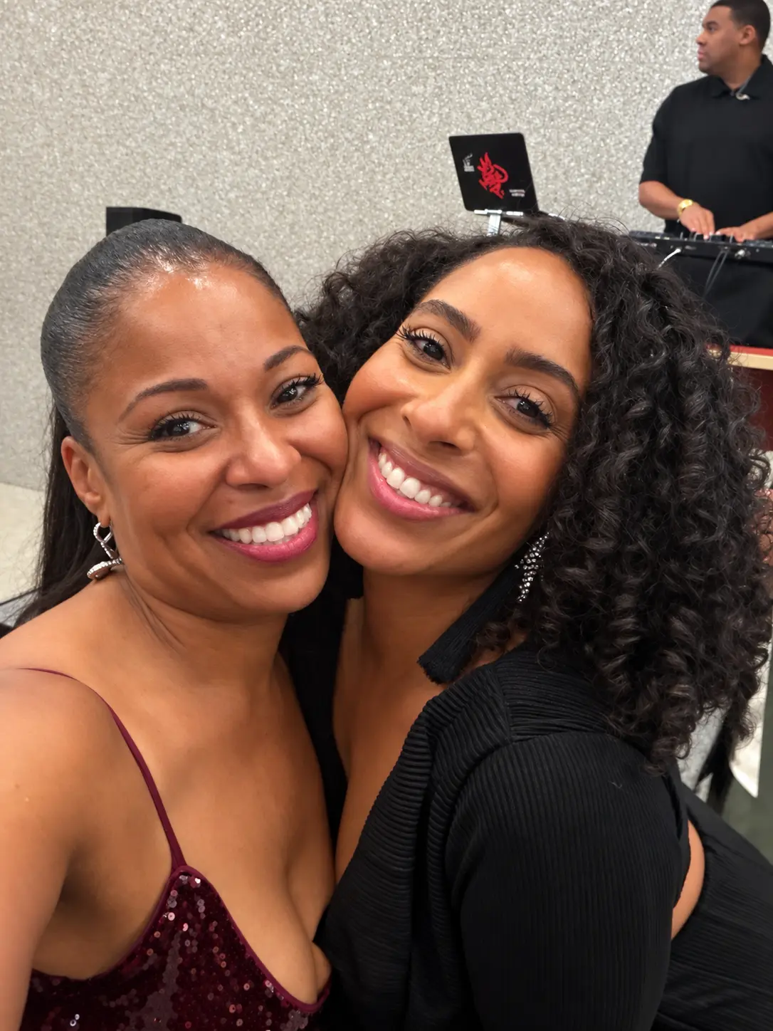 Two guests sharing a selfie near the DJ booth