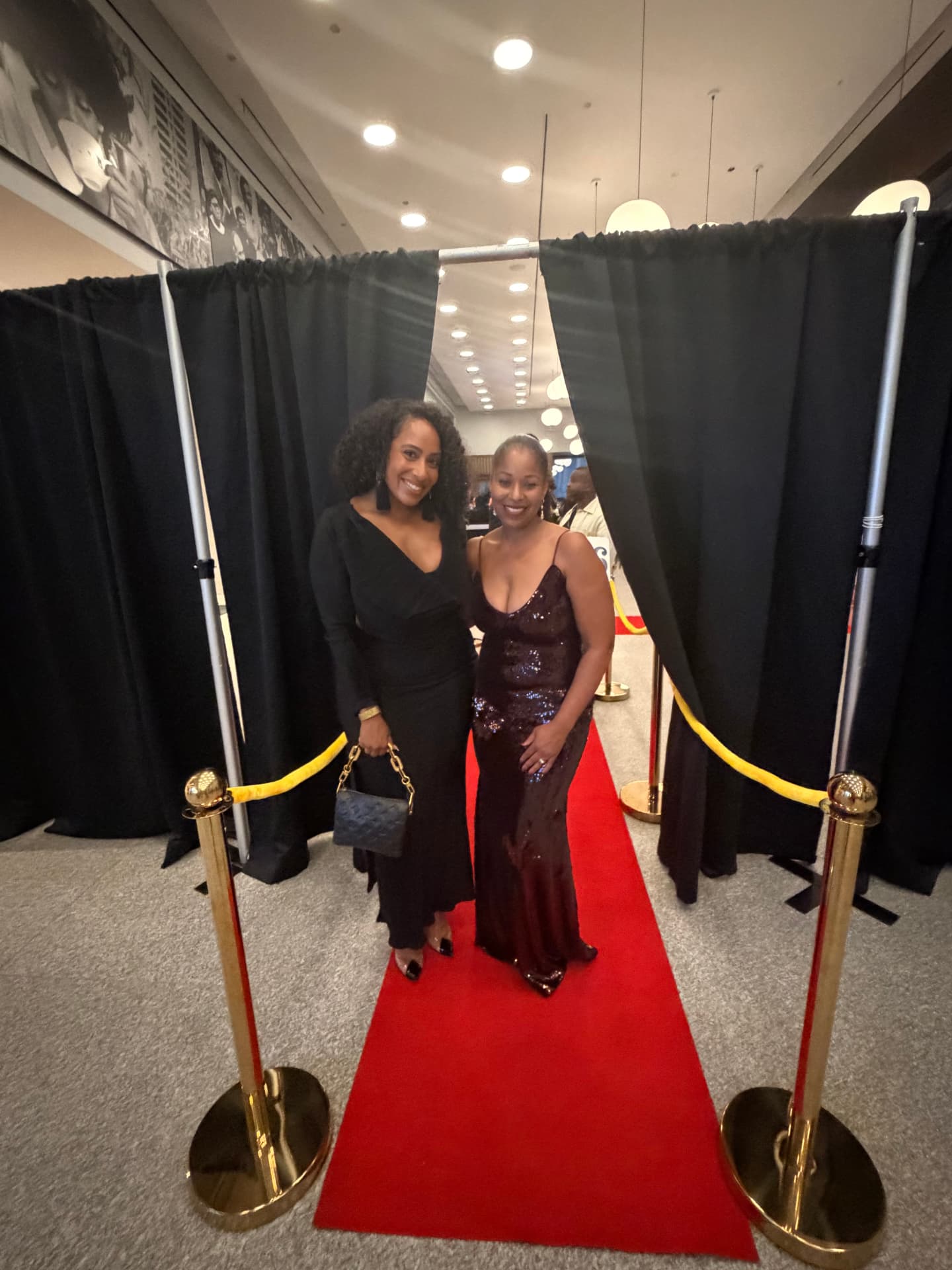 Two guests posing on the red carpet at the entrance