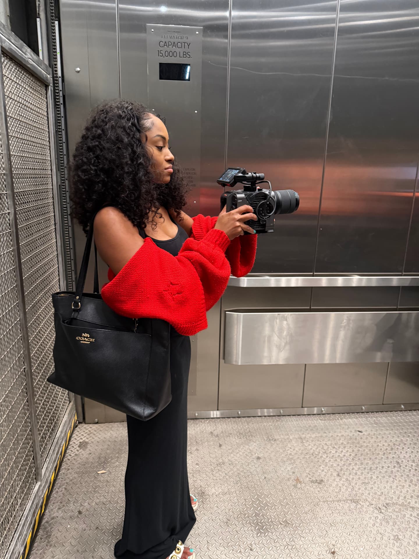 Videographer filming with a cinema camera in the elevator