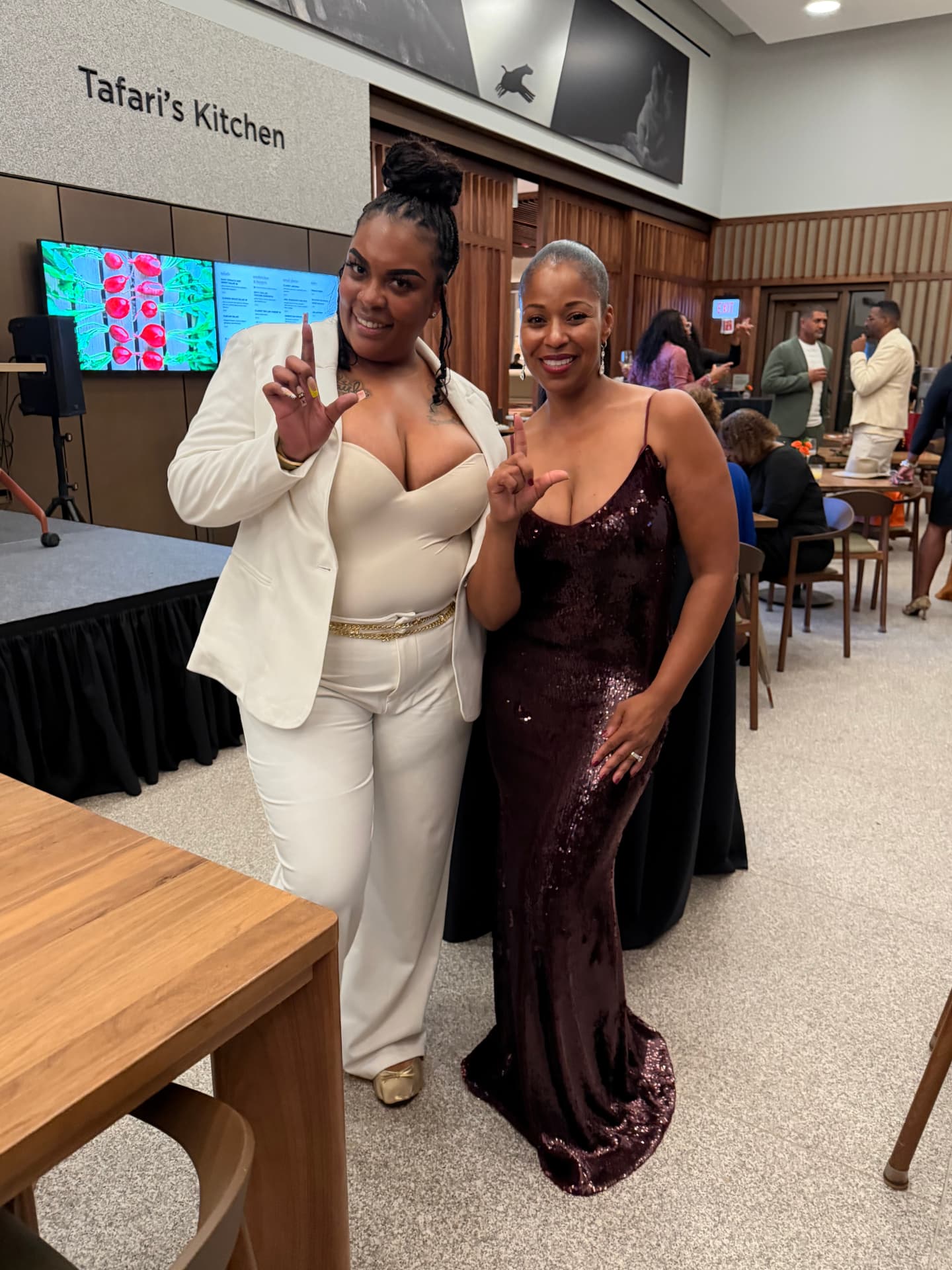 Two guests throwing up the L at the reception