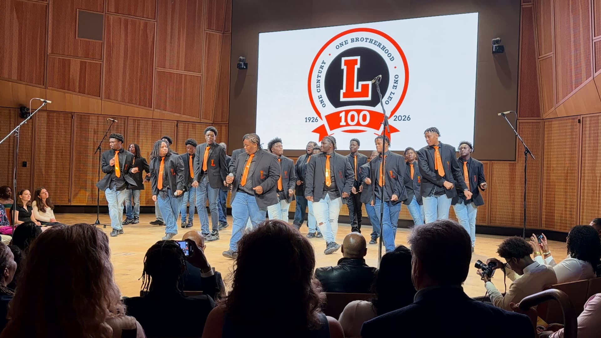 Choir members marching across the stage during a performance