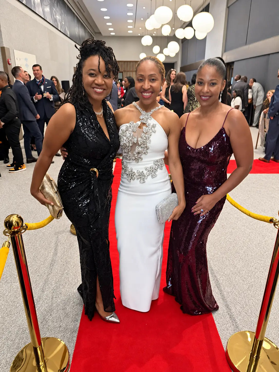 Three guests in evening gowns on the red carpet