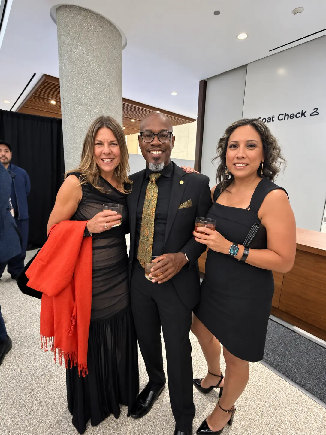 Three guests smiling together at the reception