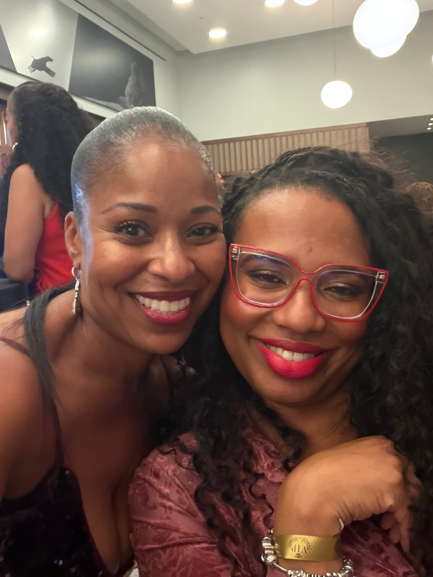 Two friends sharing a close, smiling selfie at the reception