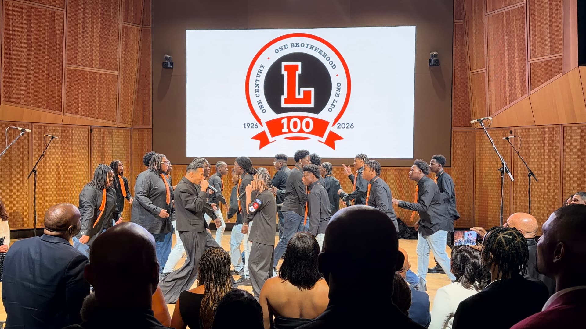 Choir members weaving across the stage around the guest vocalists
