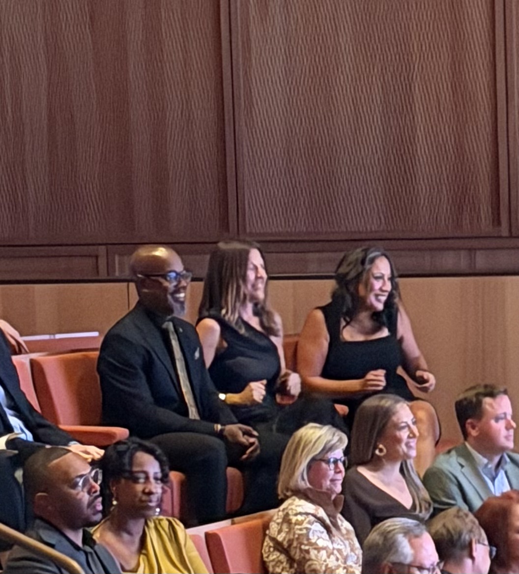 Smiling guests enjoying the performance from their seats